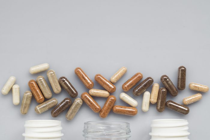 Medicinal capsule spill out of a three plastic bottles on a ligh