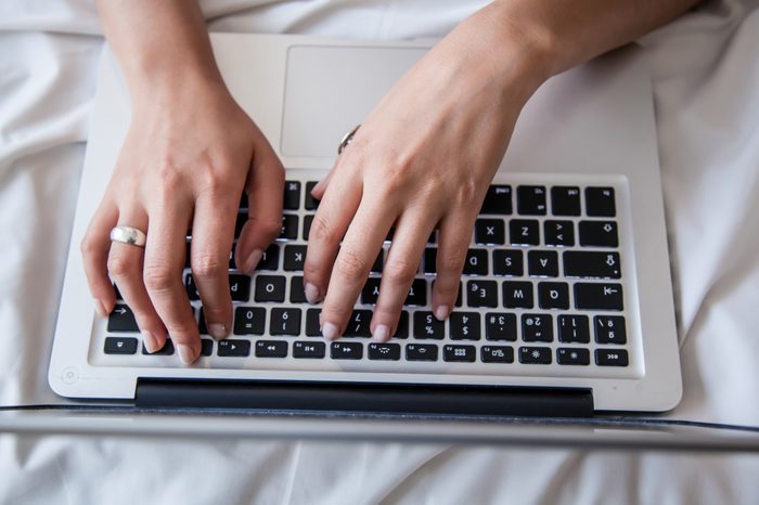 woman using laptop in bed