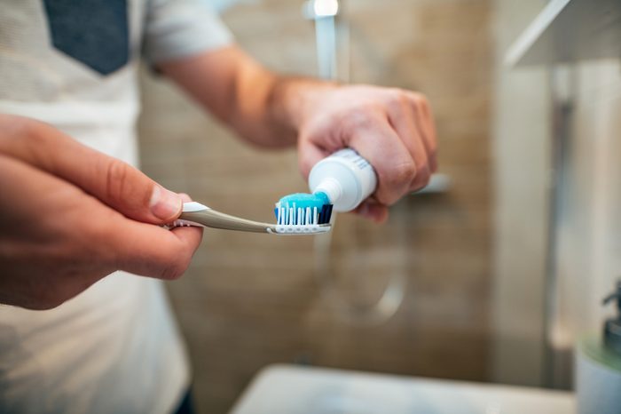 putting toothpaste on toothbrush