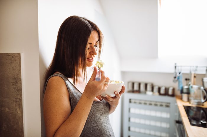 woman eating in kitchen