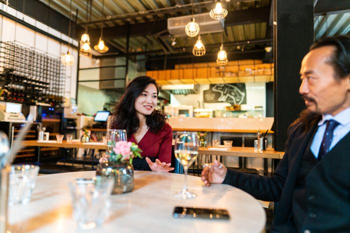 man and woman talking at dinner