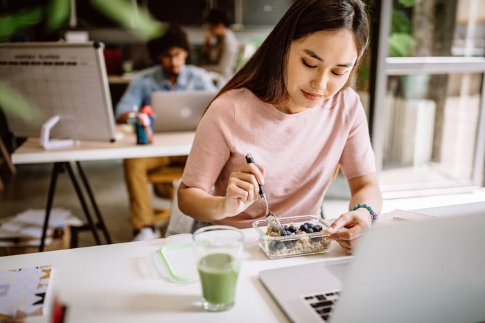 young woman eating lunch at work