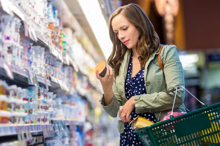 woman reading food label at grocery store