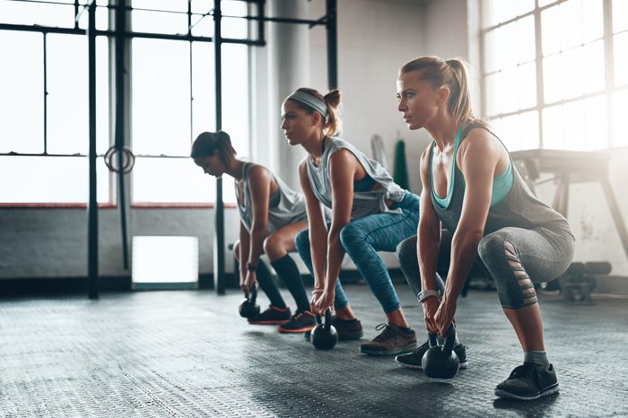 three woman doing a squat workout in the gym