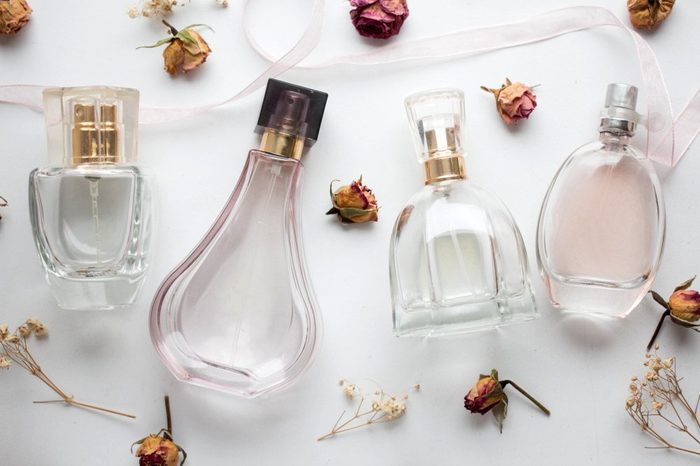 bottle of woman perfume on white background with roses. gift.