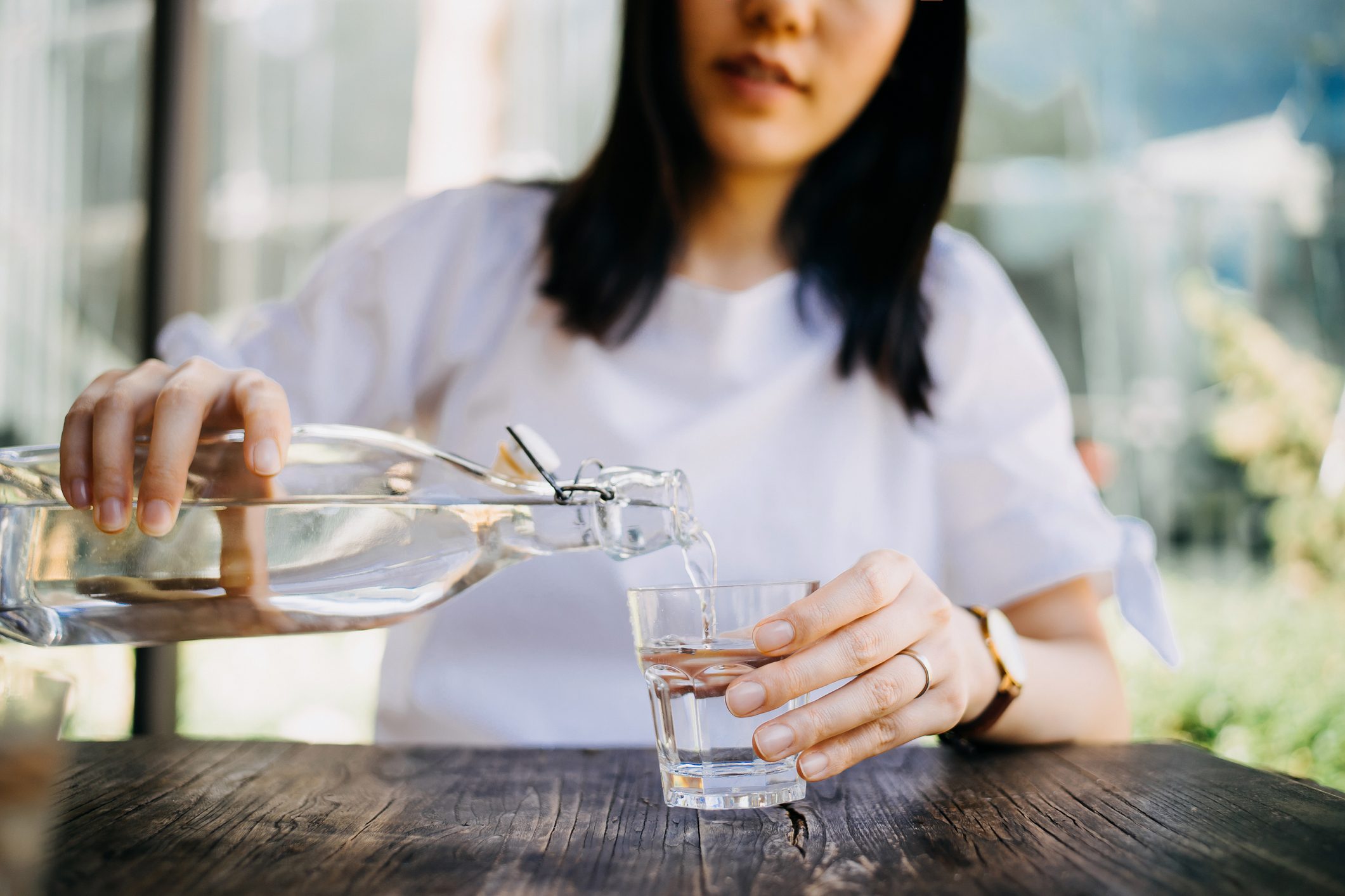 Woman pouring water from bottle into the glass