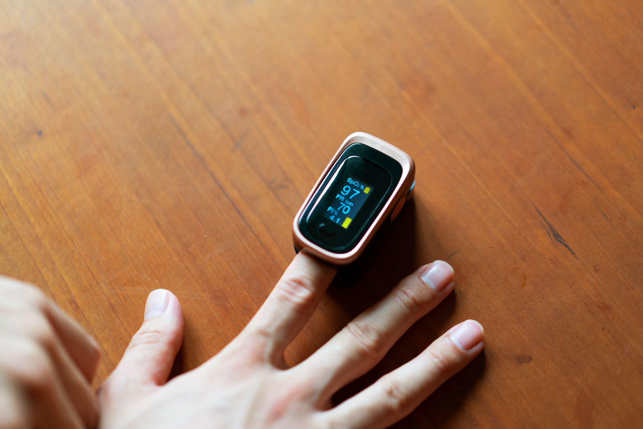 Close-up of a man in hand measuring the oxygen level in his blood with a pulse oximeter