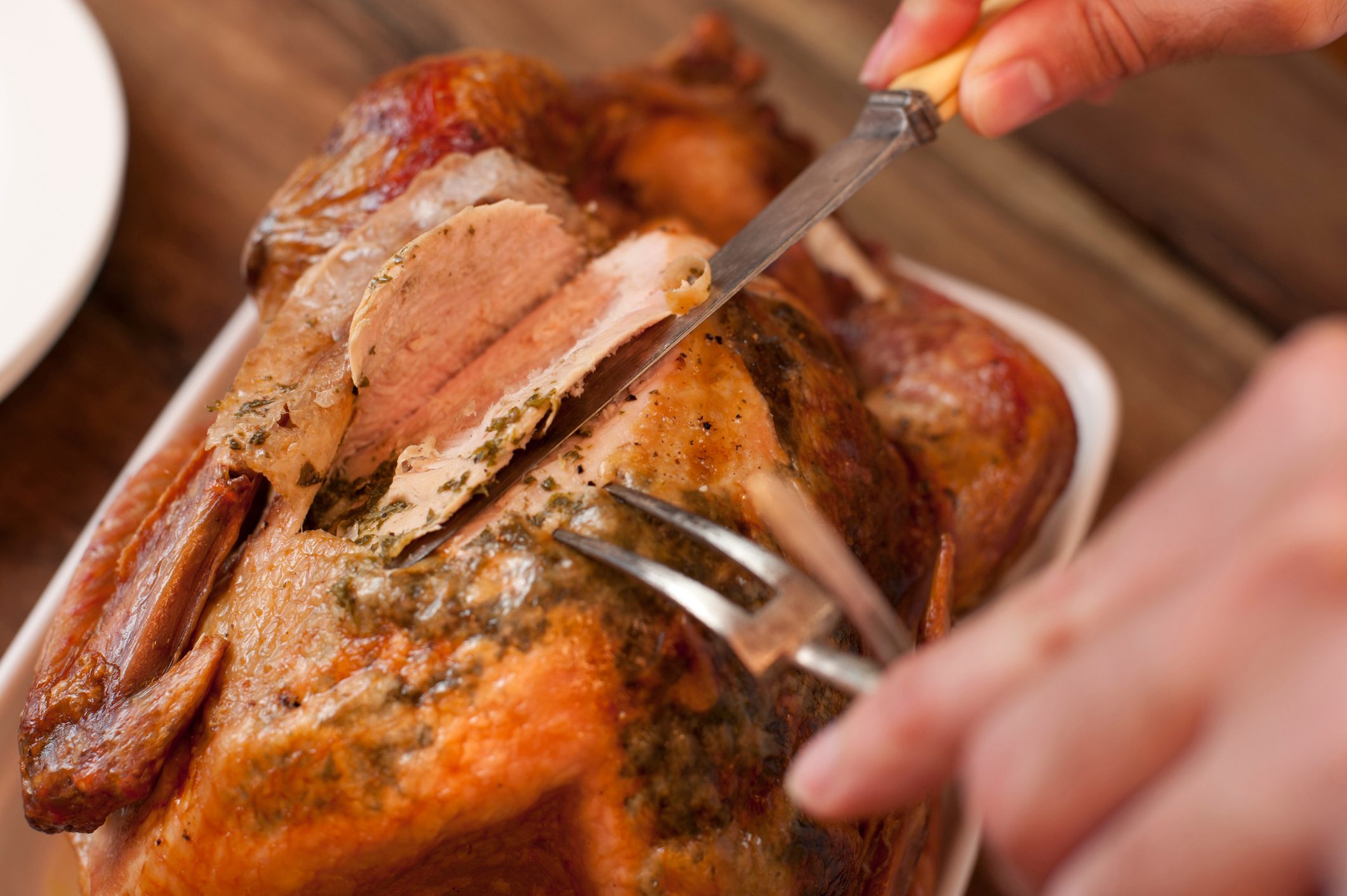 Close-Up Of Hands Carving Turkey