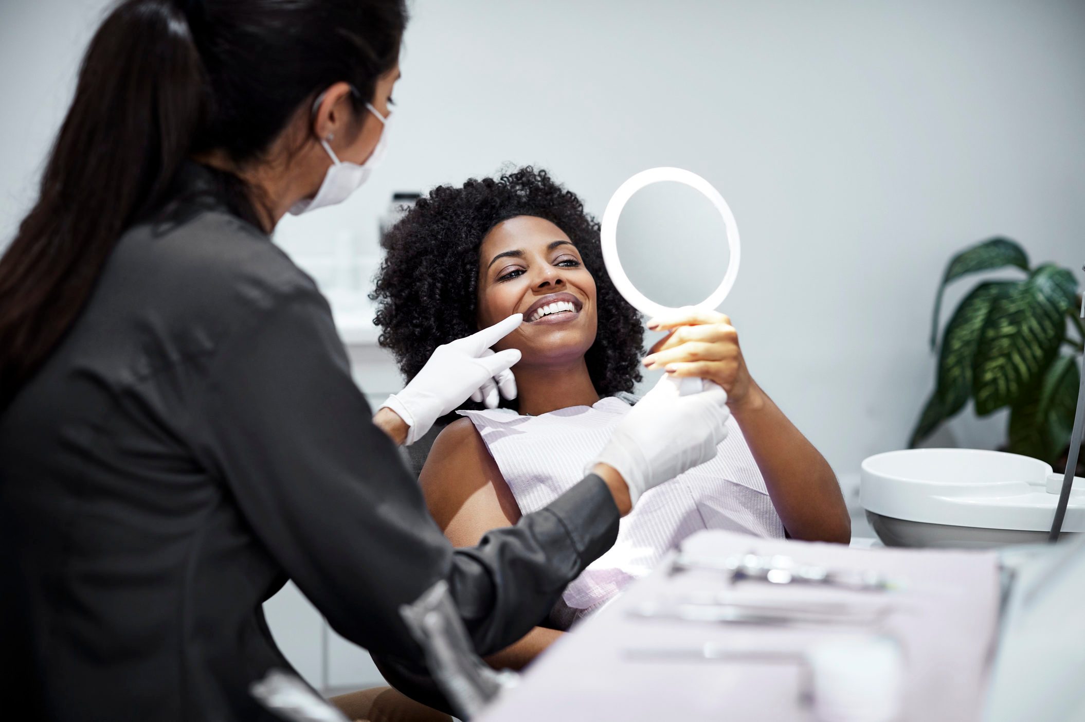 Patient looking teeth in mirror at dental clinic