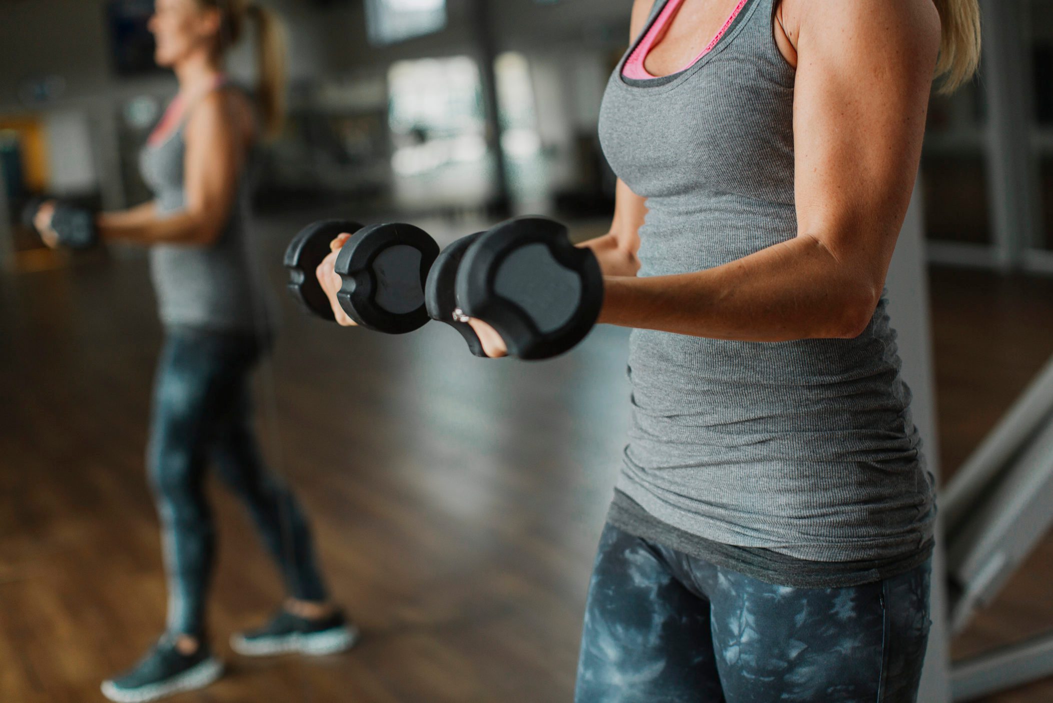 Woman exercising with dumbbells in gym