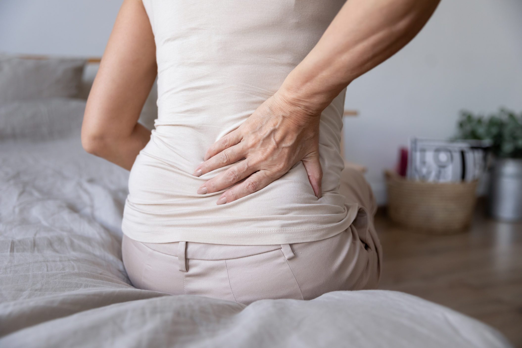 Old mature woman sit on bed touch back feel backpain