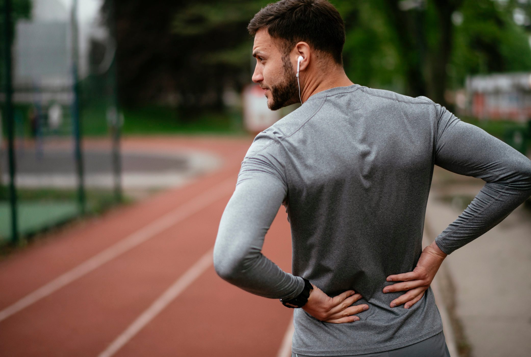 Sportsman suffering from backache at park outdoors