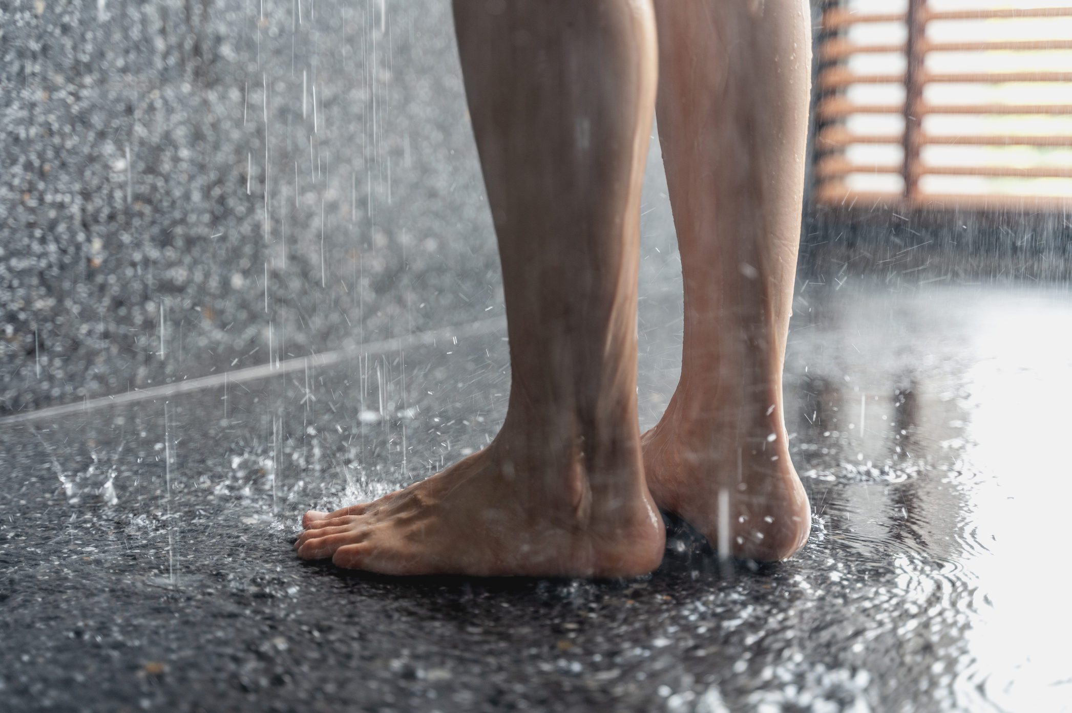 Legs and feet of someone standing in shower