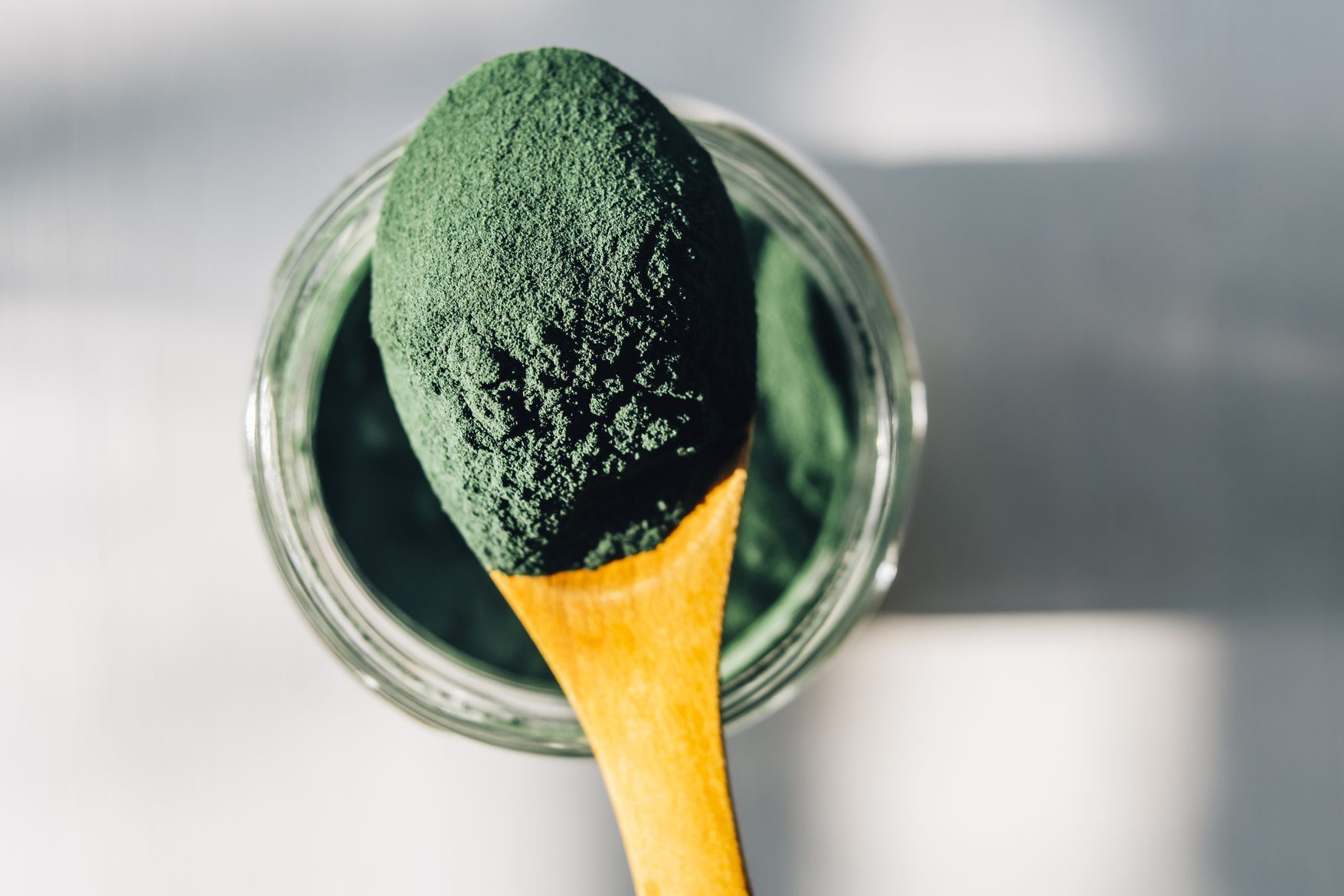 Spirulina powder in a wooden spoon