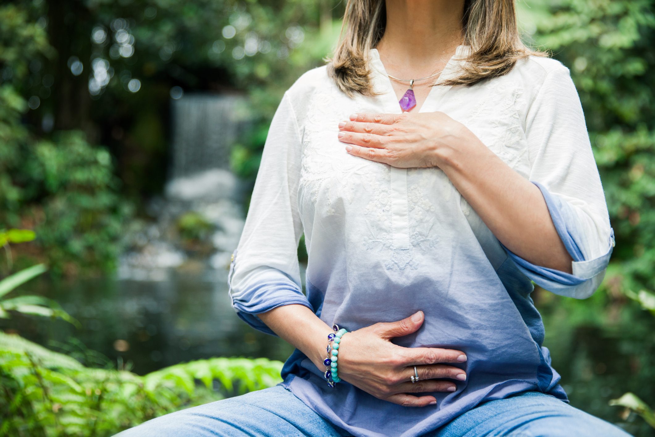 Close up of unrecognizable woman doing breathing exercises at the park