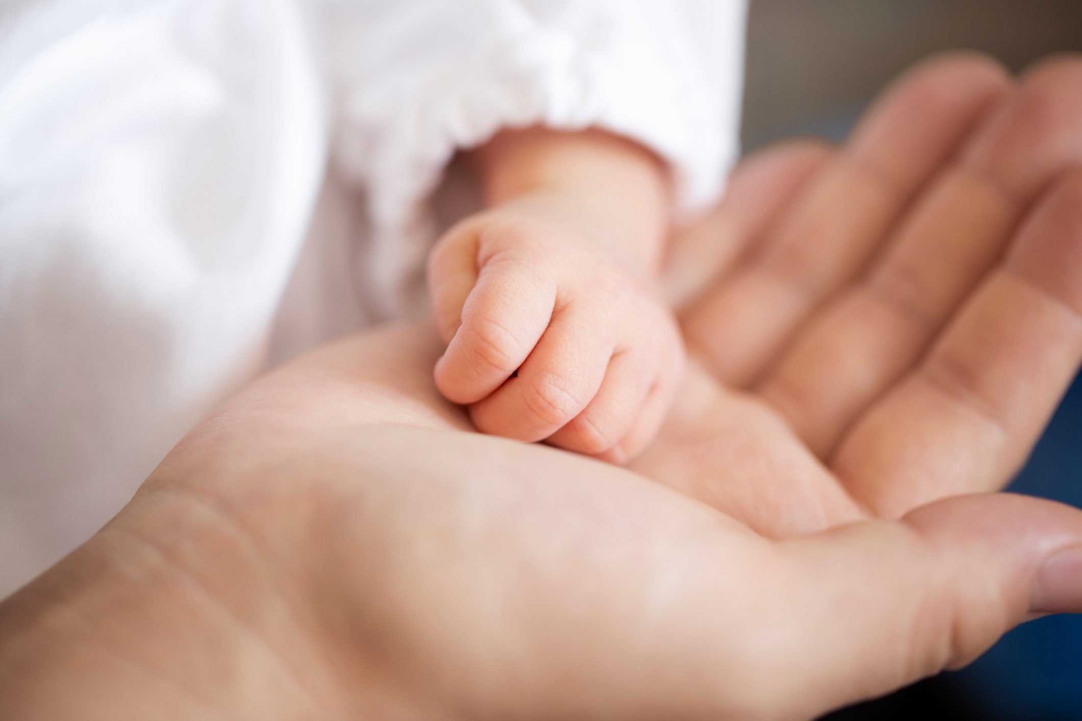 Hands of newborn baby and mother