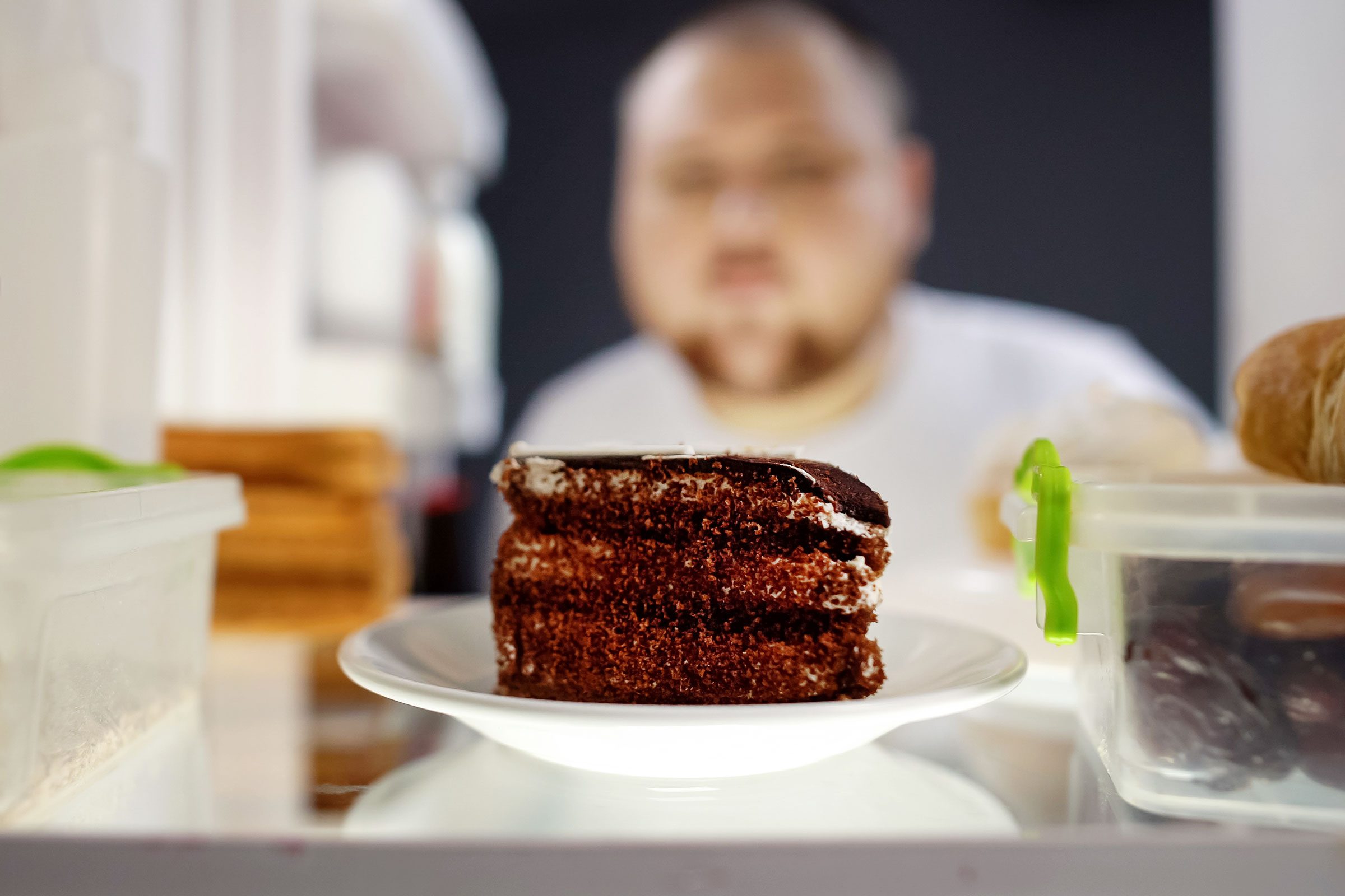 man tempted by cake in the fridge