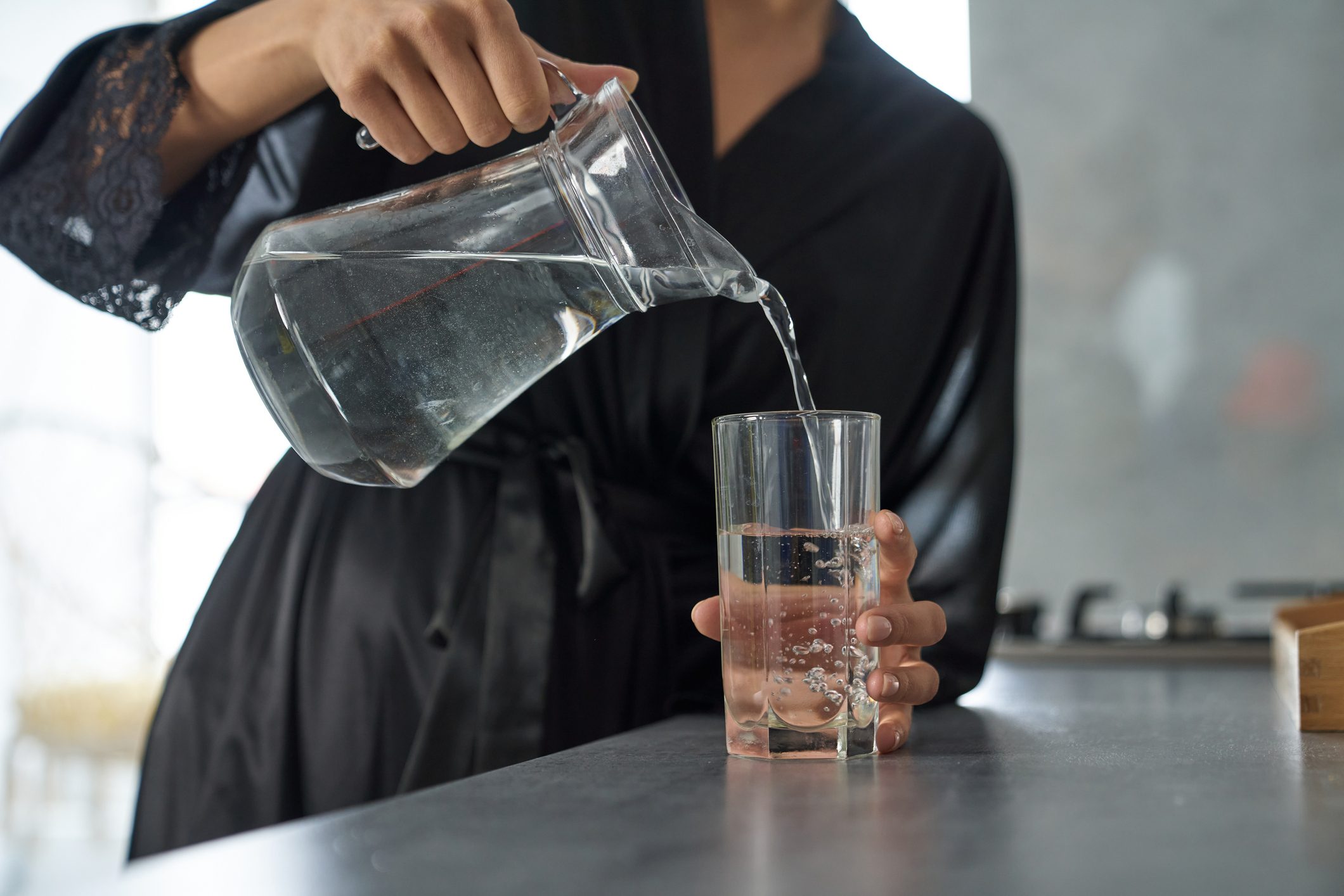 Woman in negligee drinking water at home