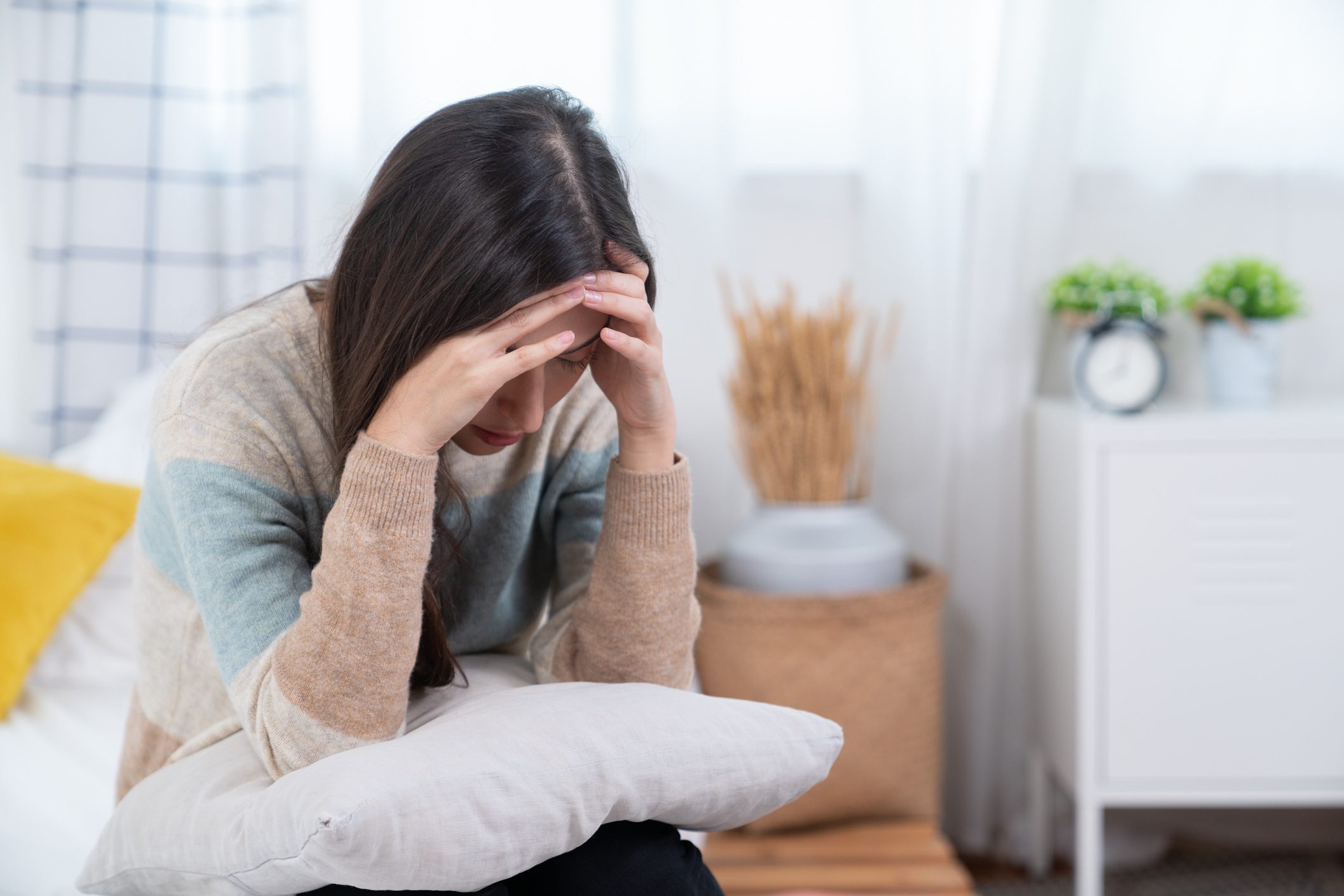 Woman suffering from stress or a headache grimacing in pain