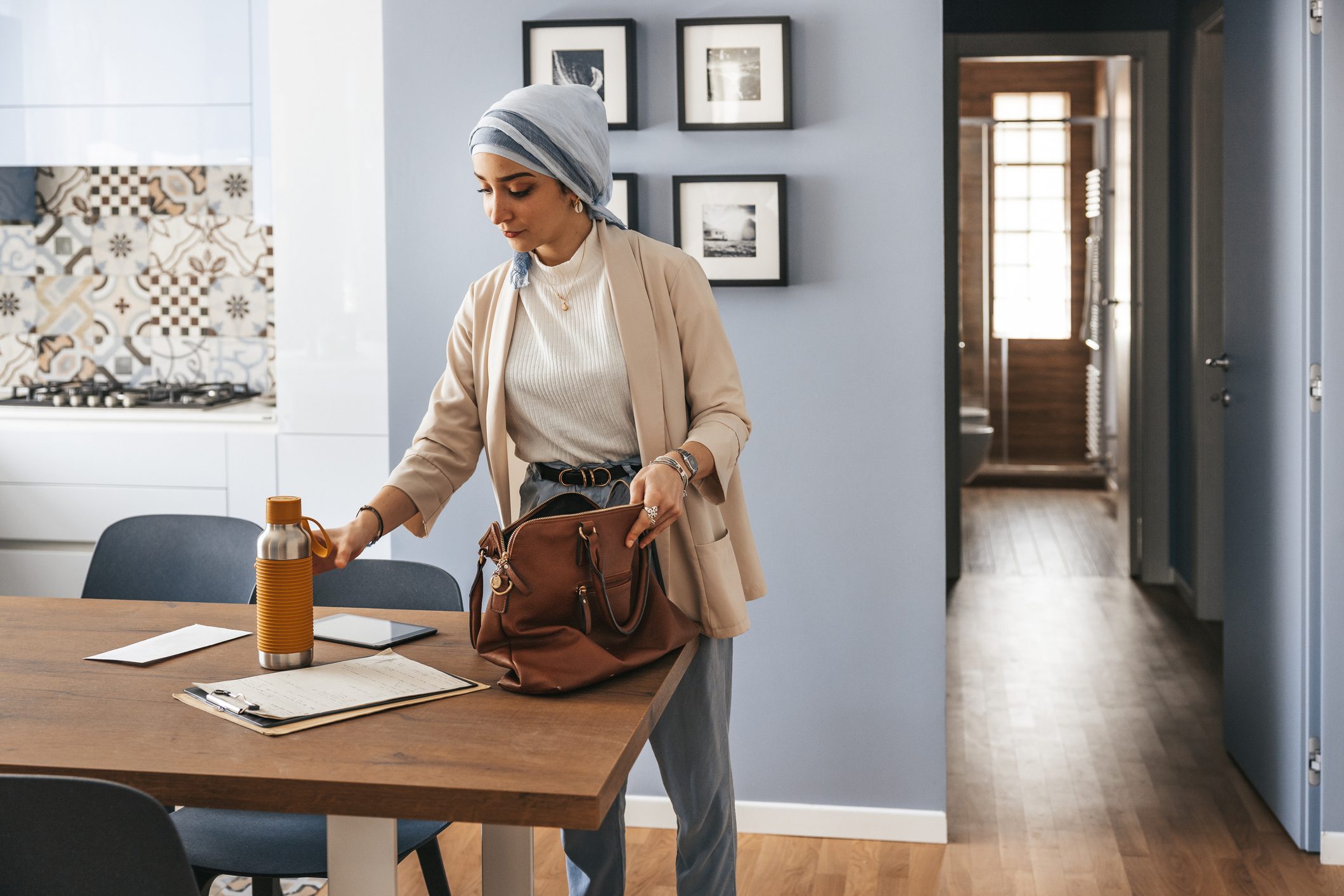 Woman gathering her purse and water bottle before going to work in the morning