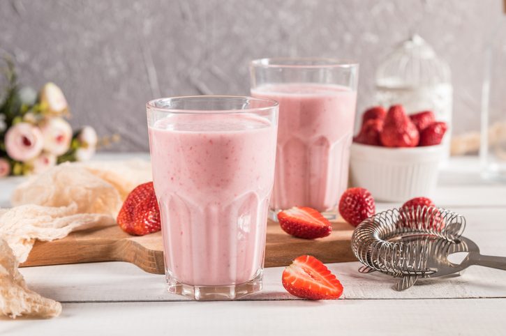 Fresh homemade strawberry smoothies on rustic background