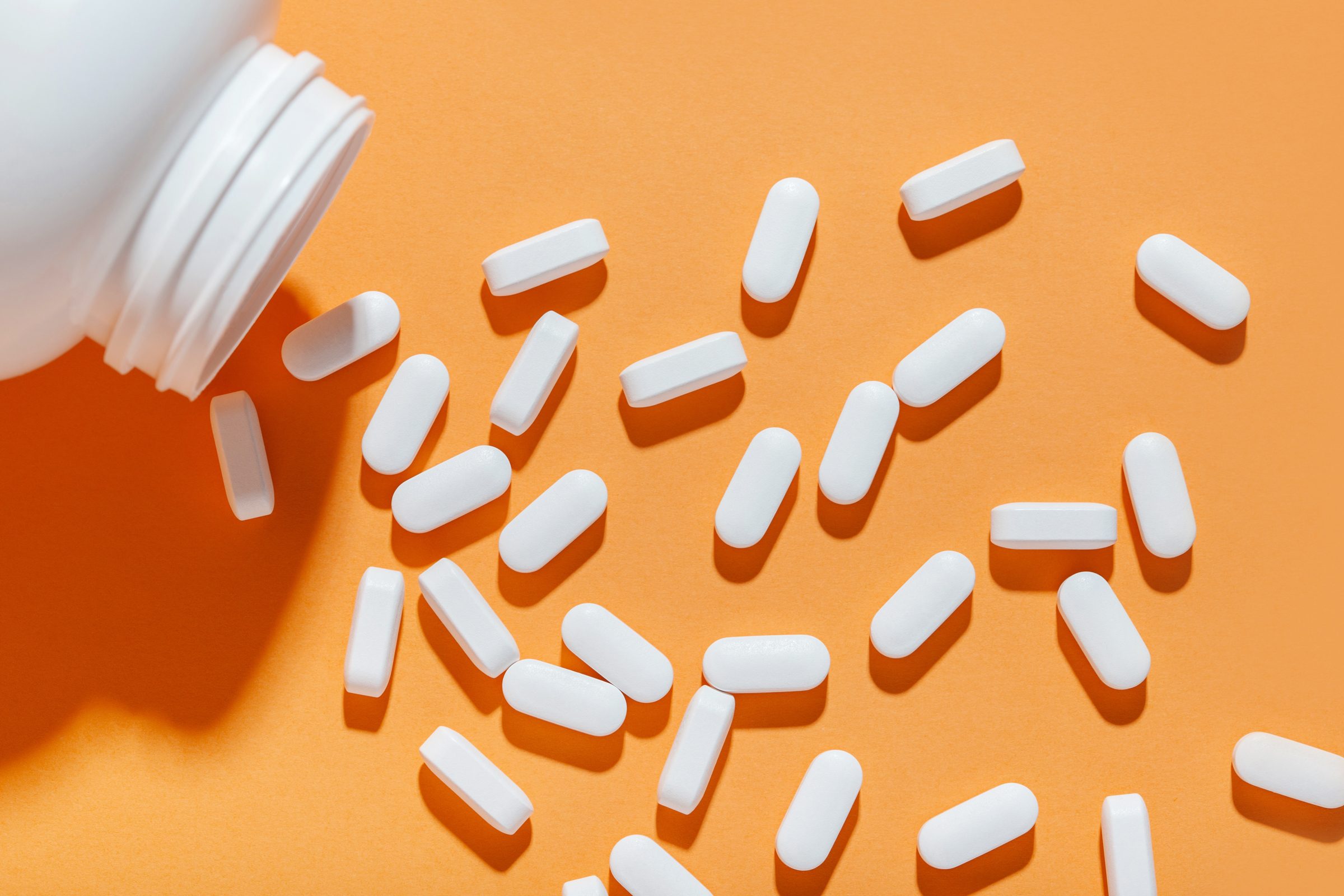 Magnesium capsules on an orange background