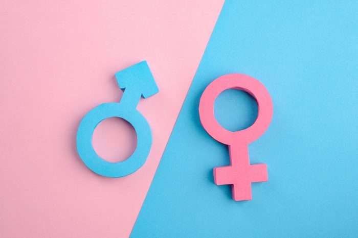 Male and female gender signs on blue and pink background. Relationship between men and women. Creative 3D paper art.