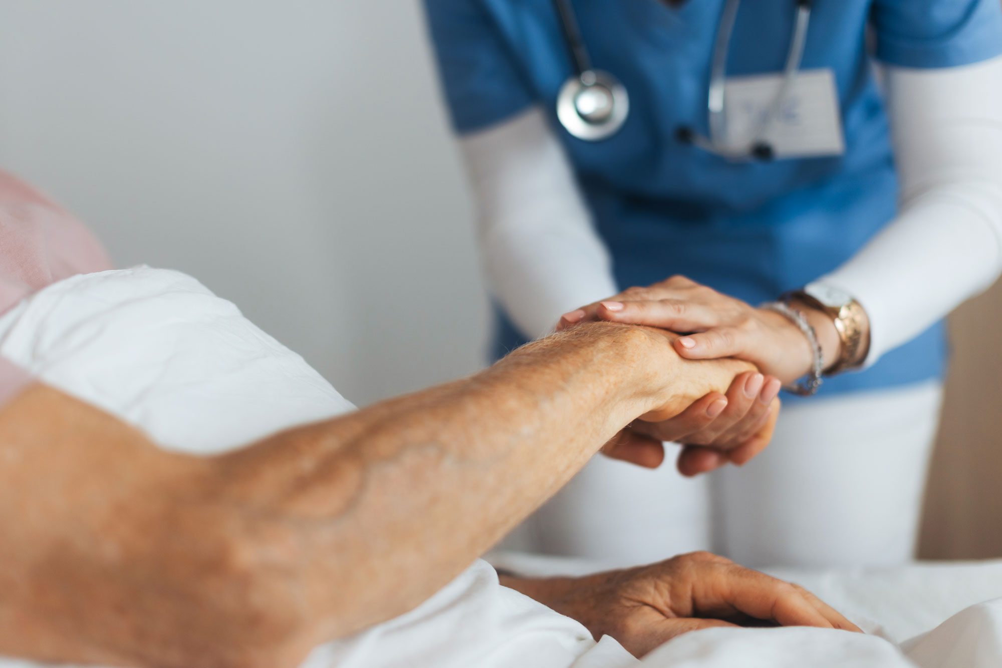 Close Up Of Caregiver Holding Senior Patient Hand