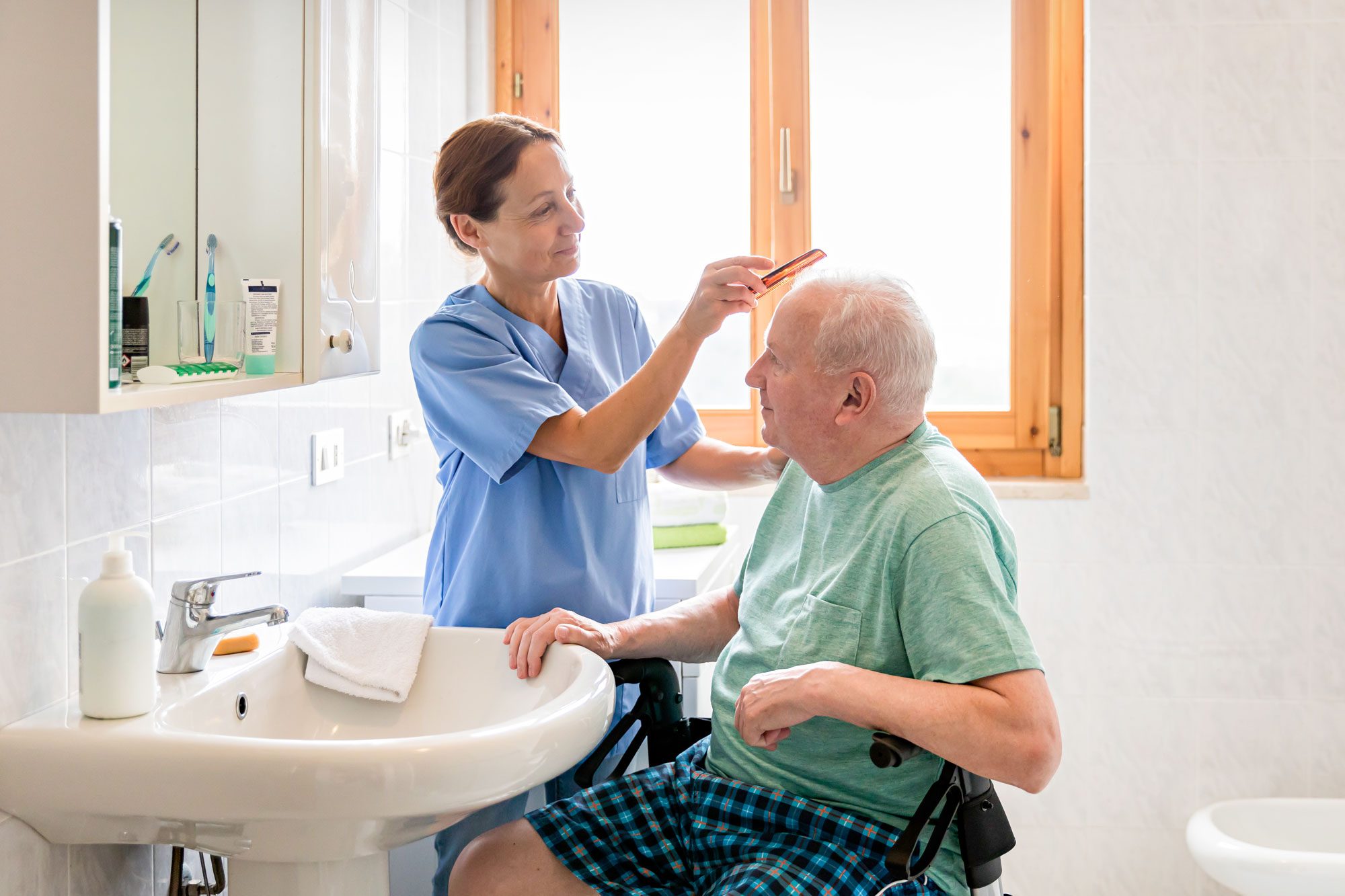 Home Caregiver With Senior Man In Bathroom