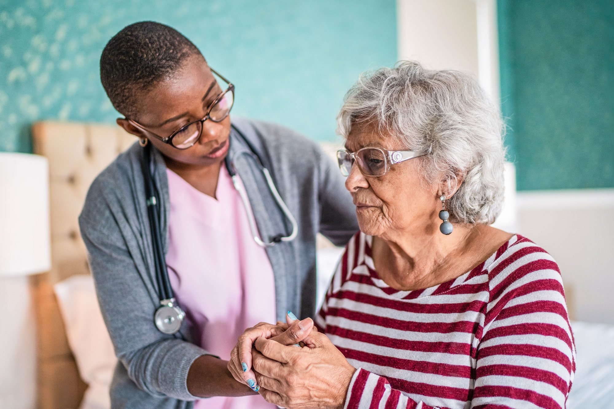 Home Caregiver Helping A Senior Woman Standing In The Bedroom