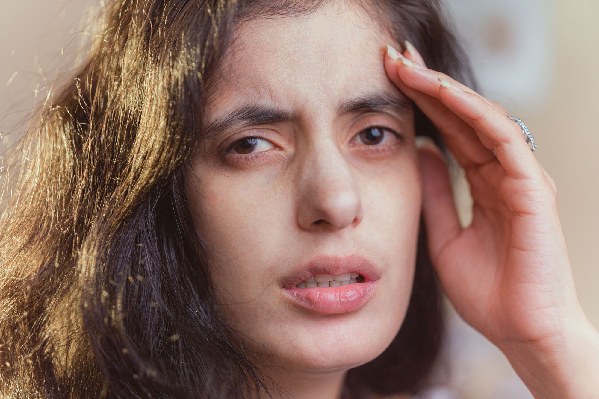 Sad And Stressed Young Woman Holds Her Head