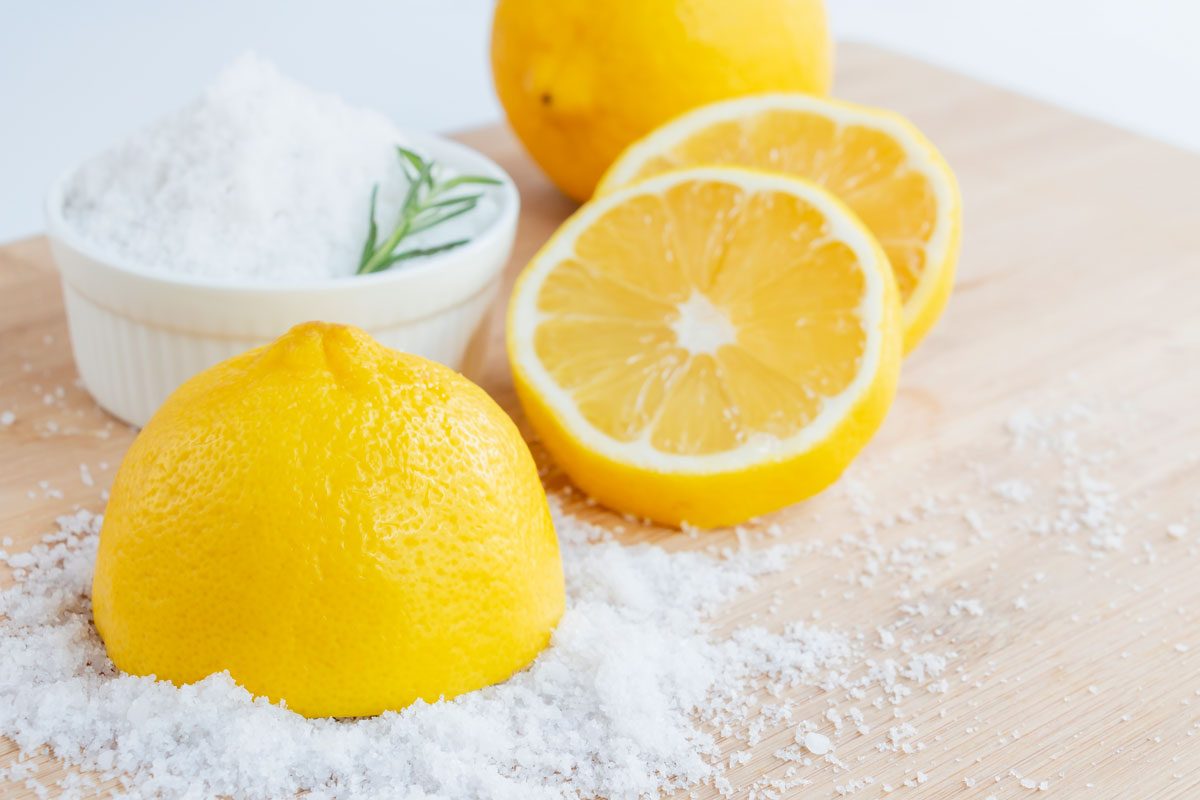 salt and lemon slices on bright backdrop as possible home remedy for corns and calluses