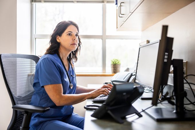 Nurse Working At Computer In Exam Room